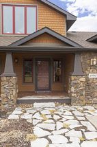 Stone bases and tapered wood columns frame the Front Entry.