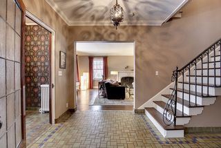 The Grand Entry Foyer features Original Tile Floors and Iron Railings.