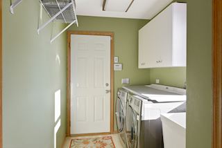Laundry room with sink, cabinets for storage and closet