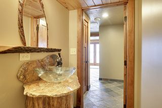 The lower level Bath located off the Game room and Lower guest Bedroom is so artistic - from the uniques base of the vessel sink to the custom mirror and special detailing throughout.