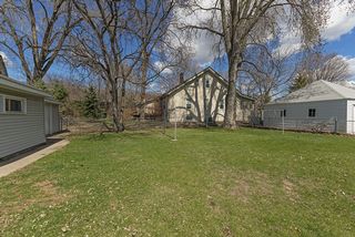 Clothes lines in a yard rimmed with majestic trees. 