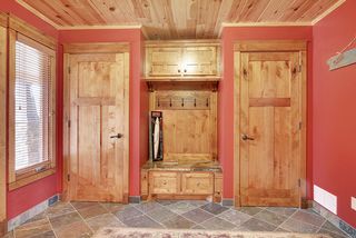 Spacious entry closets frame a boot bench and coat hanging space.