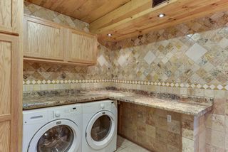 Custom travertine tile laundry room/mud room with plenty of storage and counter top space