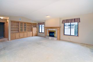 A vaulted living room with custom bookcases, a gas log fireplace and surround sound