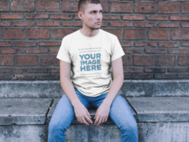 Trendy Guy Sitting in a Downtown Street Wearing a Simple Round Neck Tee Video Mockup a12231