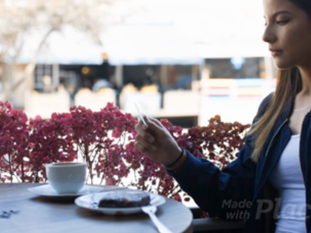 Gorgeous Woman Looking at a Business Card Video While at a Cafe a13947