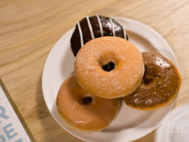 Book Video Lying on a Wooden Table Alongside a Plate of Donuts a13843