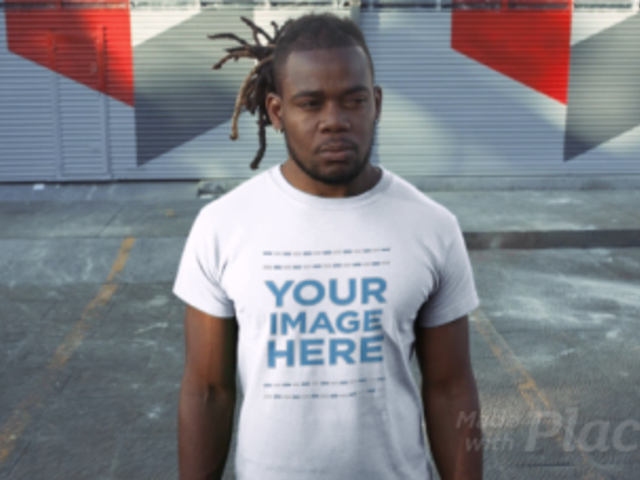 Young Black Man with Dreadlocks Standing in a Parking Lot Wearing a T-Shirt Video Mockup a12237
