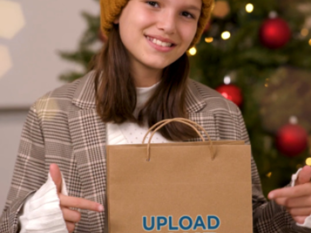 Video of a Happy Girl Pointing at a Christmas Gift Bag 6051v