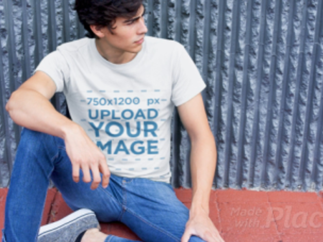 T-Shirt Video Featuring a Young Man Sitting Against a Gray Wall 12136