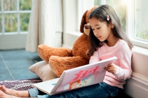 Shot of a little girl reading a book at home speech therapy dyslexia/ reading