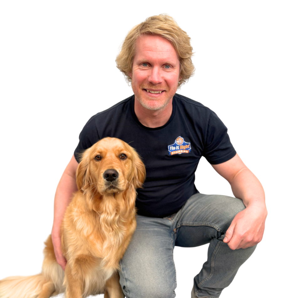 Fix-It Right Plumbing team member Richie Foster kneeling beside a golden retriever wearing a branded company shirt on a white background