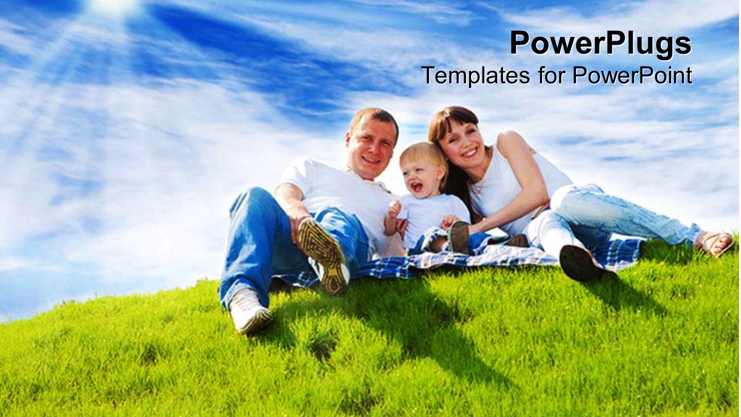 a Family of Three Smiling Happily on a Grass Field