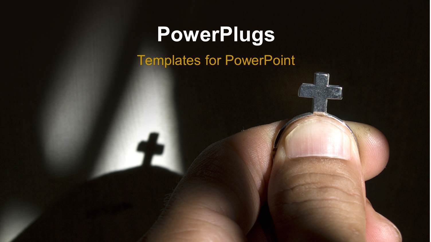 Hand Holding Metal Cross with Shadow in Background 