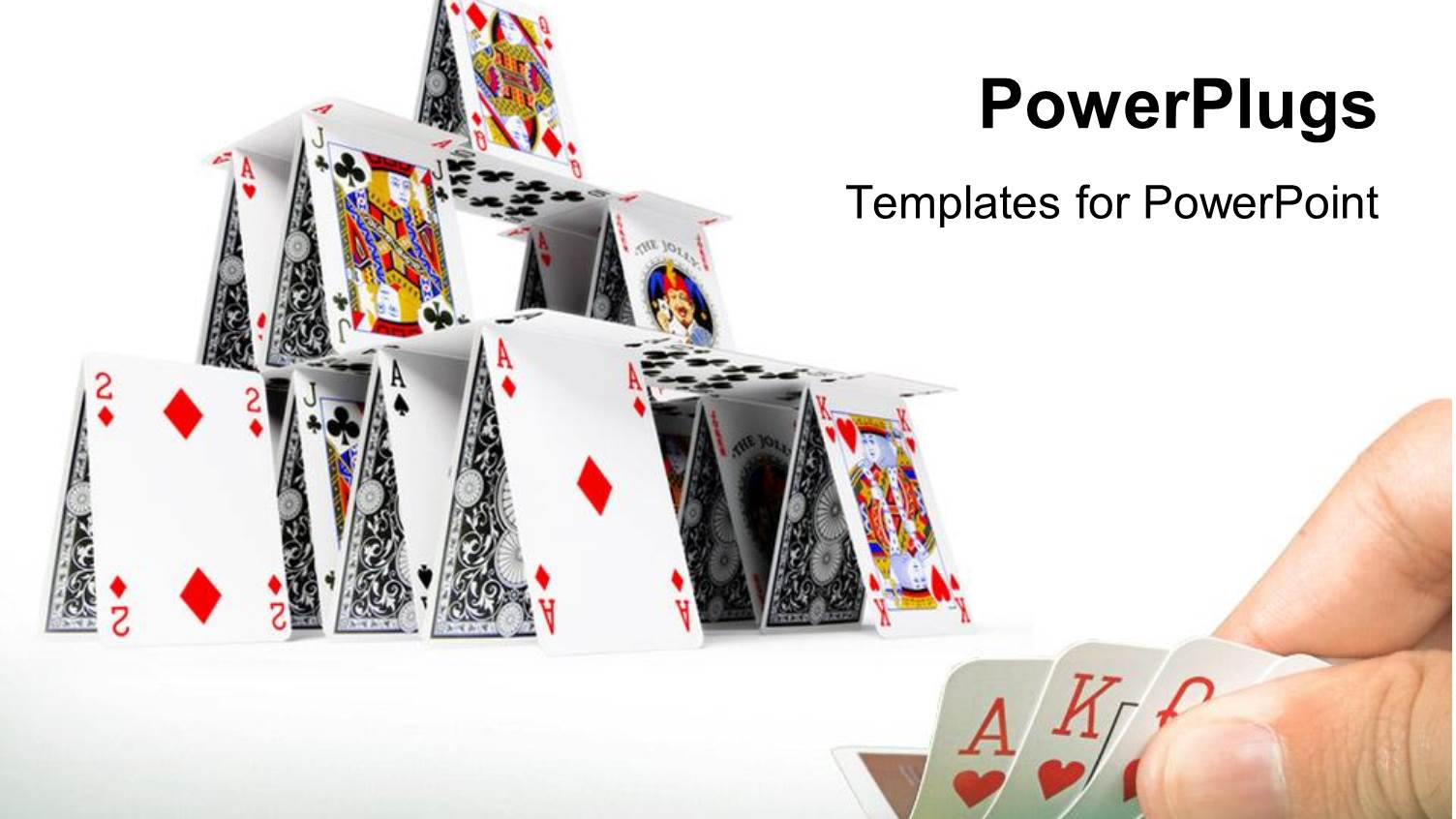 Hand Holding Playing Cards with Card House Constructed on White Background