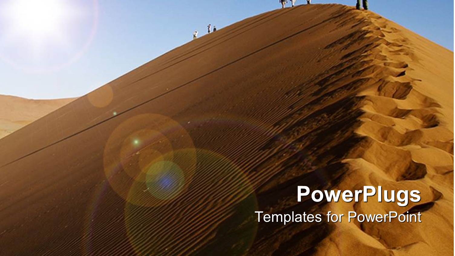 People Climbing a Desert Sand Dune on a Sunny Day