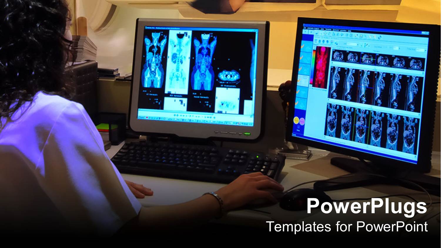 a Person Working on Two Screens Along with a a Patient in the Background