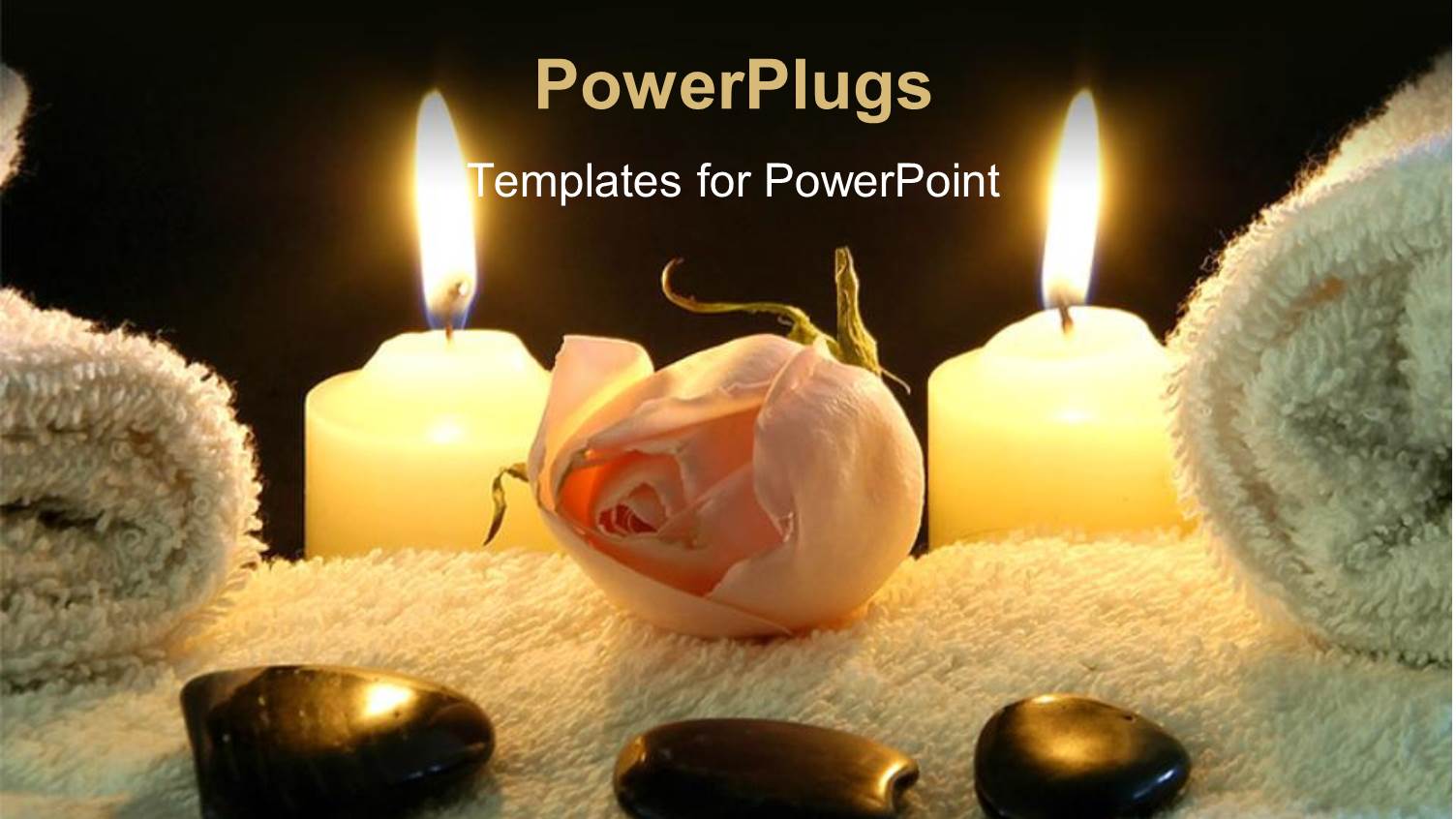 Spa Table with Stones on White Towel and Two Lighted Candles