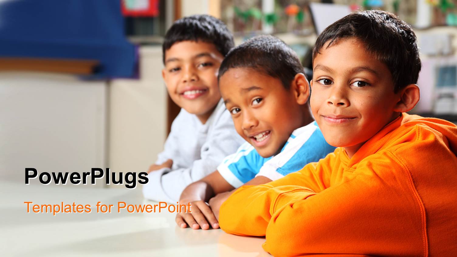 Three Male Kids Sitting and Smiling in a Class Room Setting