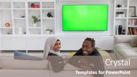 Presentation with green screen - Audience pleasing PPT theme consisting of african couple sitting on sofa watching tv together chroma green screen woman wearing islamic hijab clothes backdrop and a gray colored foreground