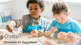  Presentation with golden christmas - PPT layouts enhanced with african schoolboy putting paintbrush into gouache while painting golden christmas toy ball at lesson with classmate near background and a lemonade colored foreground