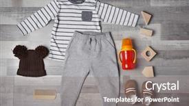  Presentation with baby clothes - Presentation theme enhanced with baby clothes and accessories on wooden background background and a gray colored foreground