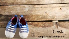  Presentation with baby shower baby shoes - PPT theme enhanced with toddler shoes on wooden background background and a coral colored foreground