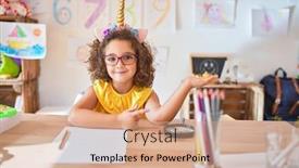  Presentation with unicorn - PPT theme with beautiful toddler wearing glasses and unicorn diadem sitting on desk at kindergarten amazed and smiling to the camera while presenting with hand and pointing with finger background and a coral colored foreground