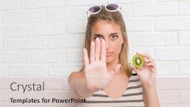  Presentation with white brick - Presentation having beautiful young woman over white brick wall eating green kiwi with open hand doing stop sign with serious and confident expression defense gesture background and a soft green colored foreground