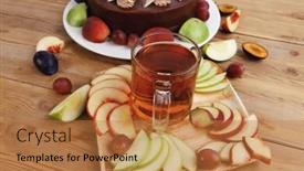  Presentation with table grape - Audience pleasing theme consisting of big whole frost chocolate cream brownie cake topped with white chocolate and cream flowers with hot tea cup decorated with fruits apple plum and grape on plate on wooden table backdrop and a coral colored foreground