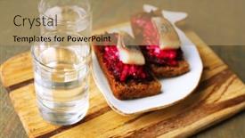  Presentation with vodka - Slides with canape herring with beets on rye toasts on wooden board and glass of vodka on wooden table background background and a coral colored foreground