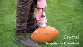  Presentation with football field - Colorful PPT theme enhanced with close up shot of man on the field pumping air into a professional ball for american football backdrop and a tawny brown colored foreground