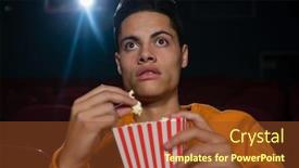  Presentation with popcorn movie - PPT theme having concentrated man having popcorn while watching movie in theatre background and a tawny brown colored foreground
