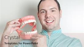  Presentation with dentures - Audience pleasing PPT theme consisting of dentist holding oversized false teeth dentures backdrop and a soft green colored foreground