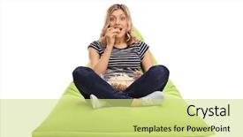  Presentation with popcorn - Theme consisting of excited woman eating popcorn seated on a green beanbag and looking at the camera isolated on white background background and a yellow colored foreground