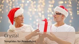  Presentation with christmas lights - Beautiful presentation theme featuring family holidays christmas age and people concept - happy senior couple in santa helper hats with gift box over lights background backdrop and a coral colored foreground