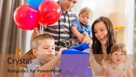  Presentation with birthday boy - Cool new presentation with family looking at birthday boy opening blue wrapped gift box at home backdrop and a coral colored foreground
