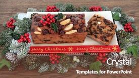  Presentation with holly - Presentation design with genoa cake and slices with merry christmas ribbon holly mistletoe and winter greenery over oak background background and a tawny brown colored foreground