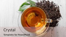  Presentation with black tea - Audience pleasing slide deck consisting of glass cup of black tea with green leaves on grey wooden background backdrop and a coral colored foreground