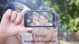  Presentation with smartphone - Beautiful presentation featuring hand holding smartphone showing against cute couple embracing in the park smiling at camera backdrop and a soft green colored foreground