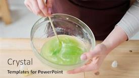  Presentation with wooden stick - PPT layouts enhanced with hands of craftswoman mixing liquid soap mass with green color in glassware with wooden stick over workplace background and a lemonade colored foreground
