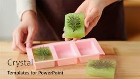  Presentation with mold - Presentation design enhanced with hands of girl holding green fresh handmade soap bar with conifer on top after taking it out of silicone mold background and a coral colored foreground