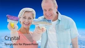  Presentation with older couple - PPT theme consisting of happy older couple holding paintbrushes against mountain peak through the clouds background and a light blue colored foreground