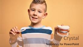  Presentation with orthodontic - Amazing PPT theme having little-kid-boy-holding-professional backdrop and a coral colored foreground