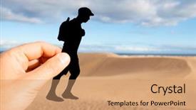  Presentation with shape - PPT theme having closeup of the hand of a caucasian man holding a paper cutout in the shape of a young man wearing a cap and carrying a backpack walking by the dunes of a desert background and a coral colored foreground