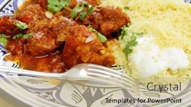  Presentation with couscous - Theme consisting of meal of chicken tagine stew in a spicy nutty tomato sauce served with couscous and yoghurt background and a soft green colored foreground