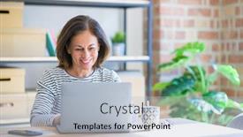  Presentation with standing sitting - Beautiful theme featuring middle age senior woman sitting at the table at home working using computer laptop with a happy face standing and smiling with a confident smile showing teeth backdrop and a light blue colored foreground