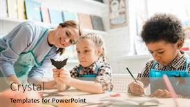  Presentation with black teacher - Slide set consisting of one of multicultural schoolkids in aprons showing handmade black paper bat to happy teacher at lesson background and a coral colored foreground
