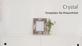 Presentation with picture frame - Presentation having picture frame perfume bottle and flora on table against white wall background and a light gray colored foreground