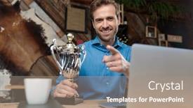  Presentation with trophy - Presentation enhanced with positive businessman pointing and holding his trophy while wearing a blue shirt sitting at a desk behind his trophy on coffeeshop background background and a coral colored foreground